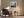Framed misty mountain forest artwork above a brown armchair beside a floor lamp and side table.