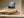Misty mountain forest artwork in a slim wood frame above a long wooden sideboard.
