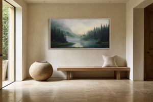 Framed misty conifer forest and river artwork above a wooden bench and round ceramic vessel.