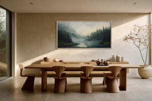 Framed mountain river artwork centered above a long wooden dining table with sculptural chairs.