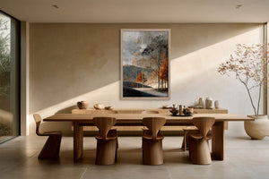 Light wood-framed autumn trees print hanging above a long wooden dining table.