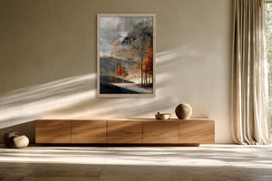 Light wood-framed autumn woodland print above a low wooden sideboard with ceramic objects.