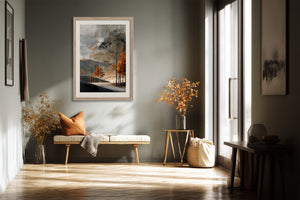 Light wood-framed autumn woodland print over a bench with an orange cushion in a hallway.