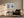 Light wood-framed mountain lake artwork above an armchair, side table, and floor lamp.