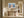 Light wood-framed mountain lake artwork above a rustic bench in a sunlit hallway.