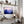Violet Ranges mountain artwork in a dark frame displayed above a desk with shelves.