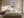 Light wood-framed mountain lake artwork above a neatly made bed between matching bedside lamps.