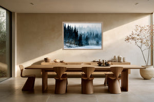 Framed winter forest artwork above a long wooden dining table with sculptural chairs.