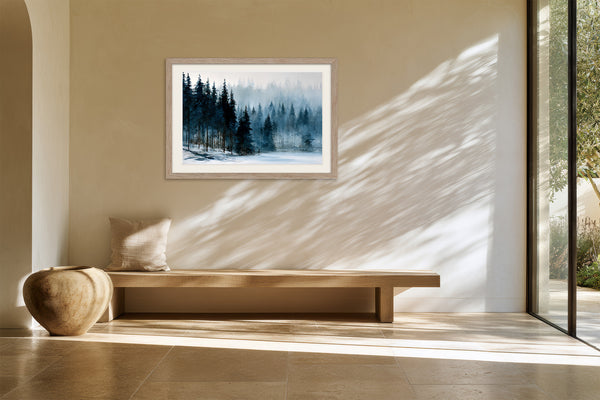 Framed winter pine forest artwork above a wooden bench near a glass door.