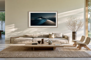 Light-framed desert dune artwork above a cream sofa and low wooden coffee table.
