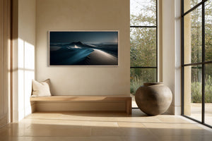 Light-framed dune artwork above a built-in bench beside large black-framed windows.
