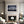 Light wood-framed mountain reflection print centered above a white fireplace between two armchairs.