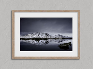 Close view of snowy mountain reflection artwork with a wide white mat and light wood frame.
