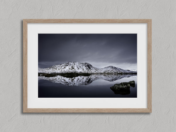 Close view of snowy mountain reflection artwork with a wide white mat and light wood frame.