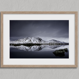 Silent Mirror shown in an oak frame with a white border or mount.