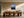 Light wood-framed mountain lake artwork above a long wooden dining table.
