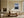Light wood-framed mountain lake artwork above a cream sofa near a fireplace.
