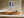 Light wood-framed winter forest path print above a low wooden sideboard.