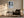 Light wood-framed snowy forest path print above an armchair, side table, and floor lamp.