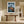 Framed mountain print above a wooden console table in a sunlit hallway.