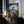 Large mountain artwork in a thin dark frame leaning on a wooden cabinet beside candles.
