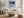 Black-framed Low Tide Light coastal print above a white sofa, wood coffee table, and woven ottoman.