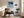 Black-framed Low Tide Light coastal print above a brown lounge chair, side table, and floor lamp.