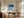 Black-framed Low Tide Light coastal print above a wood desk and upholstered office chair.