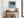 Black-framed Low Tide Light coastal print above a rustic console table with woven baskets.