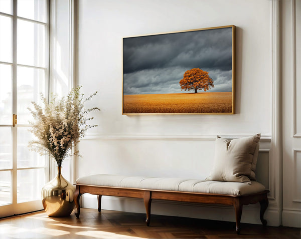 Wood-framed oak landscape above a bench in a bright white-walled space.