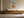 Framed geometric hare artwork above a long wooden sideboard with ceramic vessels.