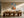 Framed geometric hare artwork above a long wooden dining table with sculptural chairs.