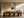Framed geometric owl artwork above a long wooden dining table with sculptural chairs.