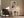 Framed geometric owl artwork above an armchair, side table, and black floor lamp.