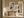Framed geometric owl artwork above a rustic wooden console table in a sunlit hallway.
