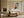 Framed geometric owl artwork above a cream sofa and low coffee table near tall windows.