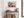 Geometric owl print in a light wood frame above a rustic console table with woven baskets.