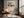 Geometric owl print in a light wood frame above a leather lounge chair beside large windows.