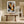 Framed winter tree artwork above a rustic wooden bench in a bright hallway.
