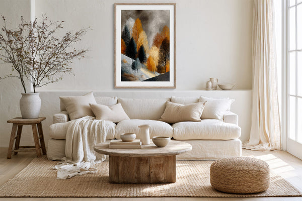 Framed winter tree artwork above a white sofa, rustic coffee table, and woven pouf.