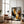 Large black-framed winter tree artwork leaning beside an armchair and floor lamp.