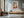 Light wood-framed geometric fox wall art above a low wooden console and chair.