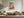 Light wood-framed geometric fox artwork above a cream sectional sofa and wooden coffee table.