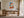 Light wood-framed orange fox print above a wooden desk in a bright workspace.