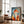 Large black-framed geometric fox artwork leaning beside a leather armchair and floor lamp.