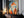 Large thin-framed geometric fox artwork leaning on a dark wooden cabinet beside candles.