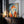 Large thin-framed geometric fox artwork leaning on a dark wooden cabinet beside candles.