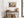 Light wood-framed orange fox artwork above a rustic console table with woven baskets and vessels.
