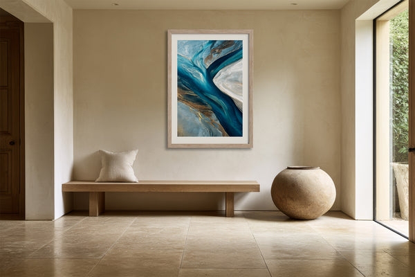 Framed teal, navy and grey abstract artwork above a wooden bench and large round vessel.