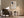 Framed beige and charcoal abstract artwork above an armchair and side table with floor lamp.